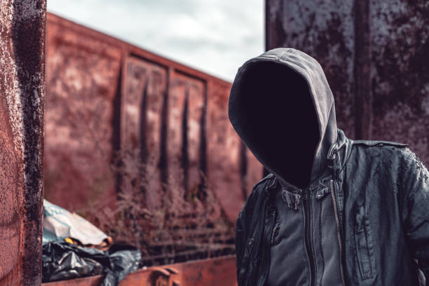 istock Faceless hooded homeless man among old obsolete freight train wagons 1190032657