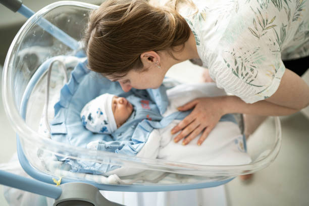 istock Smiling mother talking to her sleeping newborn 1190034139