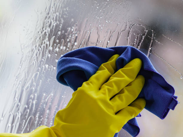 istock Gloved hand cleaning window rag and spray 1190035635
