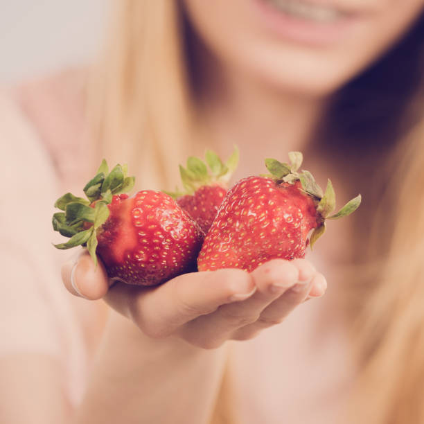 istock Girl showing fresh strawberries 1190038423