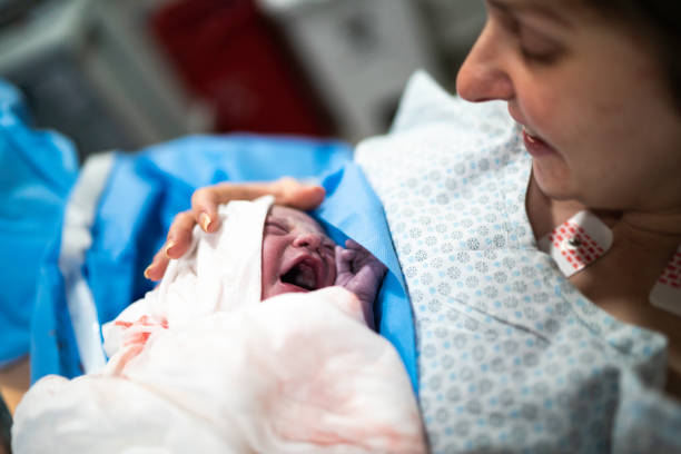 madre sorridente che tiene il suo bambino in ospedale - cesarean foto e immagini stock