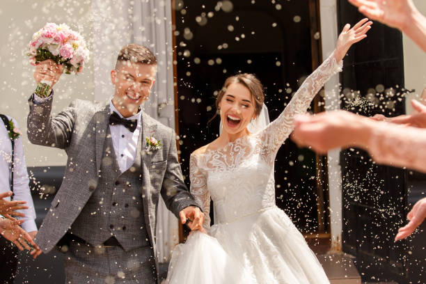 결혼식에서 신부와 신랑의 행복한 웨딩 사진. 쌀과 곡물을 뿌린 결혼식 전통 - white wedding 뉴스 사진 이미지