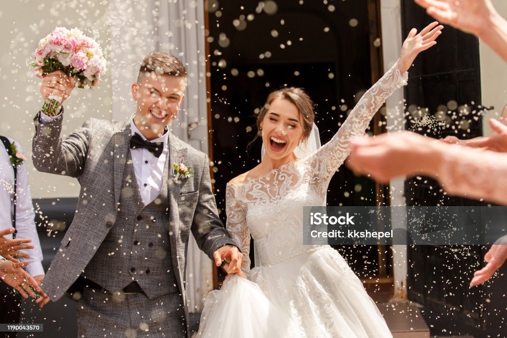 Happy wedding photography of bride and groom at wedding ceremony. Wedding tradition sprinkled with rice and grain Wedding Stock Photo
