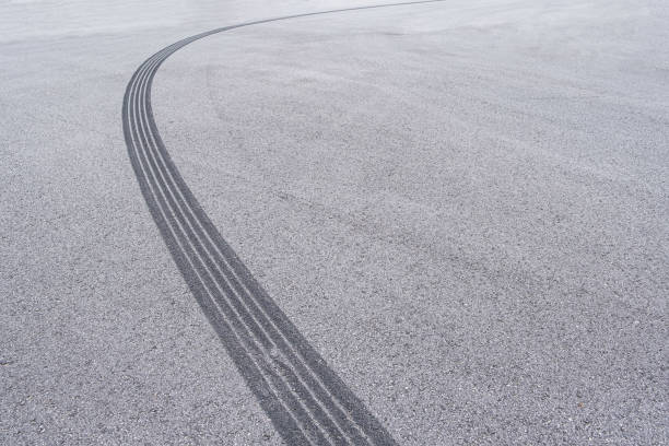 istock Curved tyre track on asphalt with copy space 1190045274