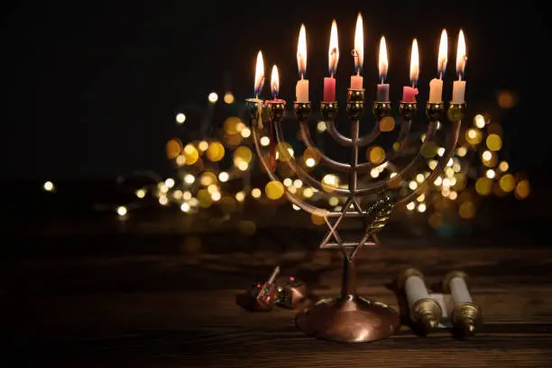 Concept of jewish holiday Hanukkah with menorah (traditional candelabra) and burning candles.