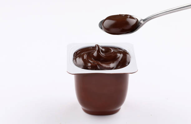 chocolate pudding cup plastic  with spoon on white background chocolate pudding brown cup plastic  with spoon isolated on white background custard photos stock pictures, royalty-free photos & images