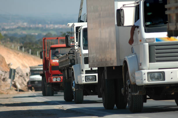 Row of unrecognisable trucks at rest area. All logos and identifiable plates have been removed carefully