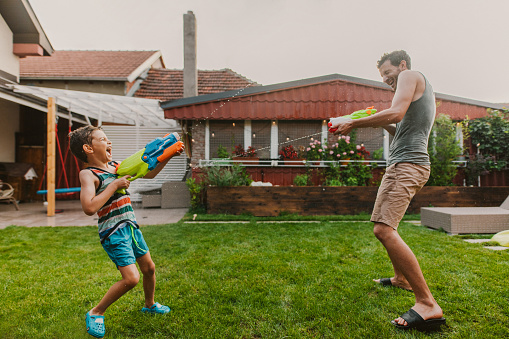 Photo of family water fight in the yard