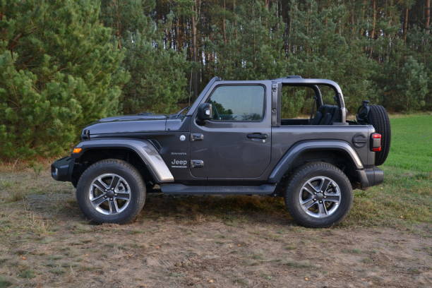 jeep wrangler auf einem gras - editorial sports utility vehicle car jeep stock-fotos und bilder