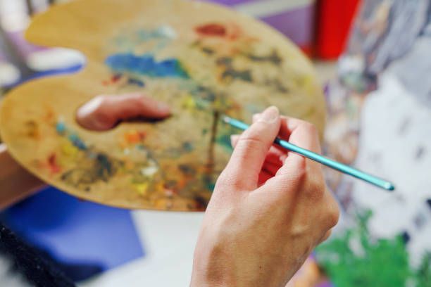 カラーペインティングで絵画ブラシとアーティストパレットを持つ若い女性画家アートの手を閉じます - artists canvas palette paintbrush oil painting ストックフォトと画像