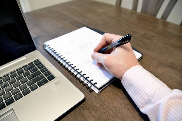 istock Man Brainstorming on Page and Laptop 1190058905