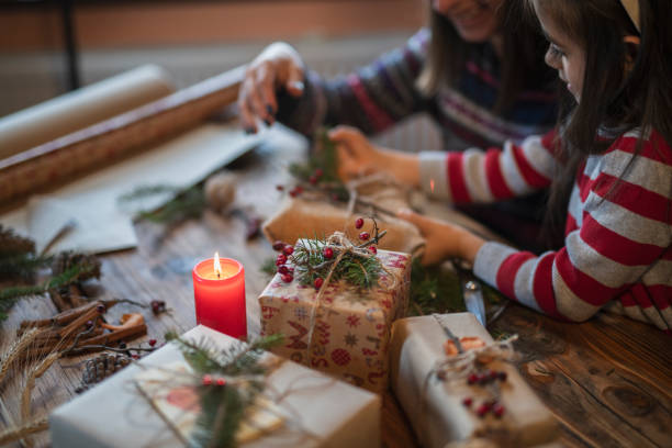 família feliz que faz presentes do natal em casa. - empacotar atividade - fotografias e filmes do acervo