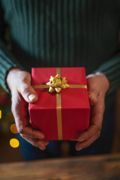 istock Male Hands Holding Red Christmas Present 1190059355