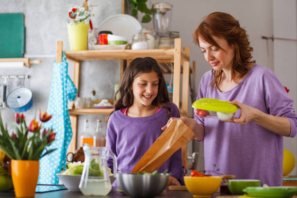 istock Mother packing school lunch for her daughter 1190059398