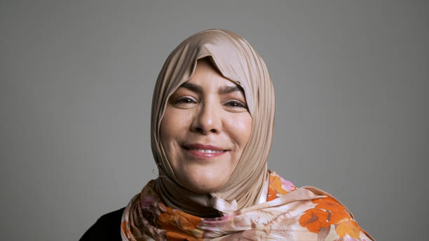 mature muslim woman looking at the camera mature muslim woman looking at the camera on gray background chubby arab stock pictures, royalty-free photos & images