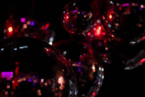 Disco balls sparkle in darkness of night club