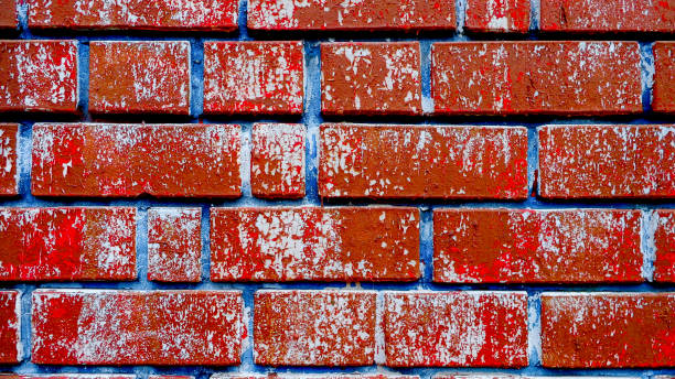 istock Colorful brick wall with cracked reddish paint and blue joints, dark loft background 1190065740