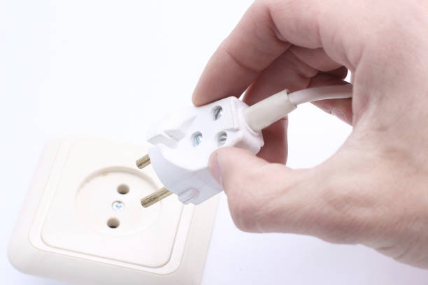 istock close up of a hand including a fork in an electrical outlet. 1190072764