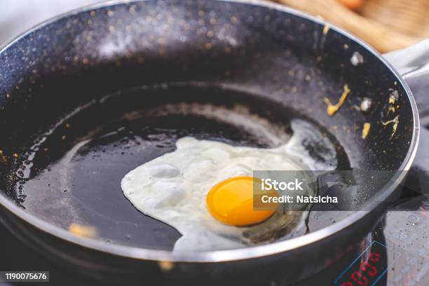 Yellow Yolk Egg Fried Egg Cooking On Flying Pan In Oil On Electric Stove Close Up Selective Focus With Copy Space Stock Photo - Download Image Now
