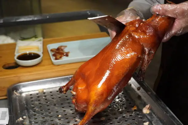 Photo of Chef slicing Traditional Peking duck.