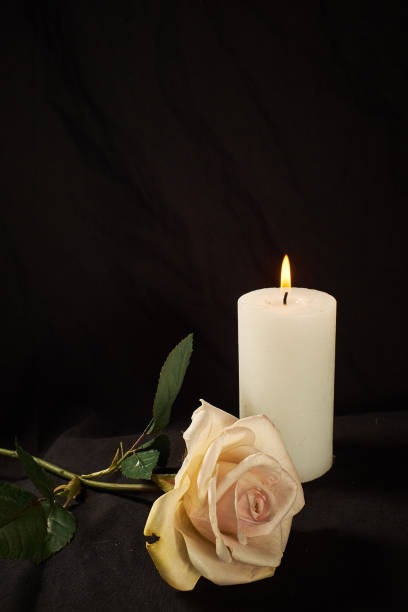 istock Burning  candle and a beautiful rose on a black background 1190081415