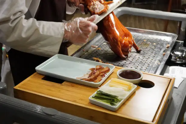 Photo of Chef slicing Traditional Peking duck.