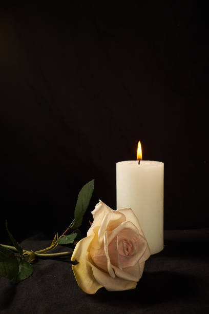 istock Burning  candle and a beautiful rose on a black background 1190081460