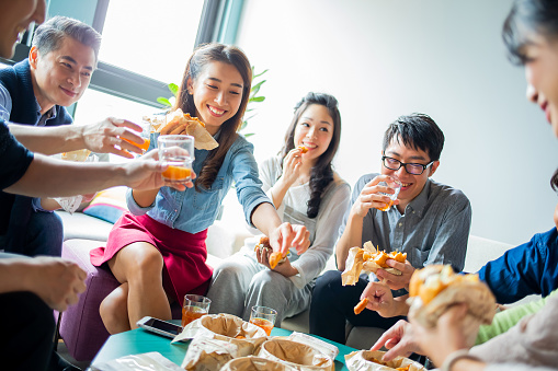asian colleagues enjoy their lunch in modern office happily