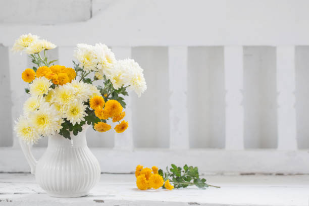 istock yellow chrysanthemums in jug on old  white wooden bench 1190086192