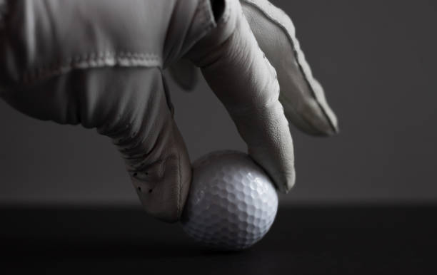istock hand in glove keep golf ball on black background 1190088913