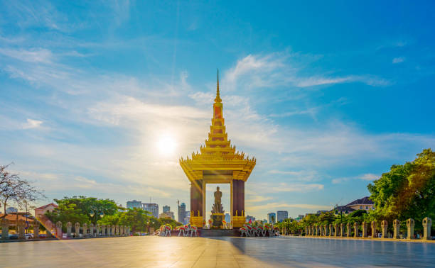 une statue du père de roi norodom sihanouk avec le ciel bleu et jaune dans le fond de coucher du soleil du soir au centre de phnom penh, capitale du cambodge. - traditional culture flash photos et images de collection