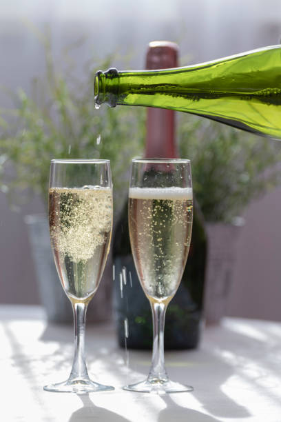 istock Serving a luxurious bubbling champagne in two glass glasses 1190099740