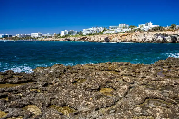 Rocky shore, clear turquoise sea water and blue sky in Ayia-Napa, Cyprus, hotels.