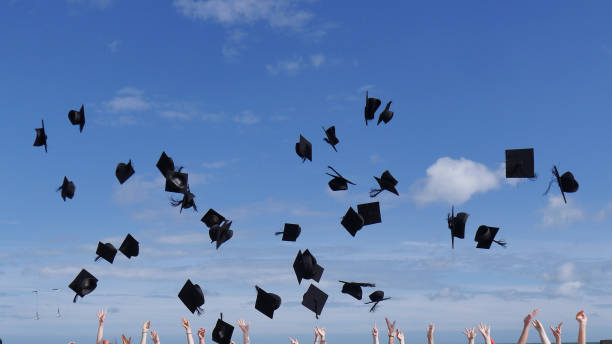 istock Graduates celebrating and throwing caps 1190106780