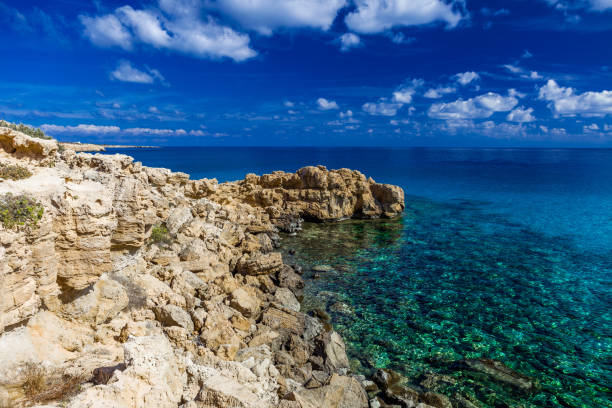 istock Sea coast with clear turquoise water, stone cape, blue sky with clouds. 1190106944