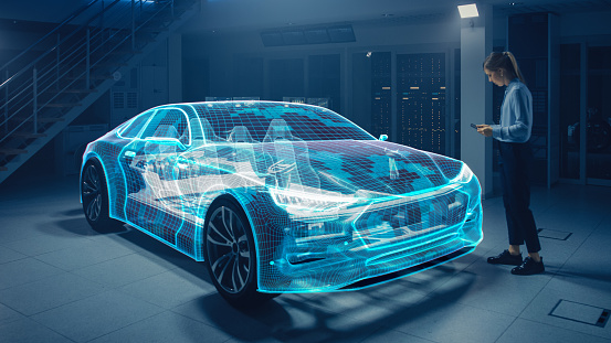 Female Automotive Engineer utiliza la tableta digital con realidad aumentada para la edición y mejora del diseño de automóviles. La visualización de gráficos 3D muestra prototipos de vehículos completamente desarrollados analizados y optimizados photo