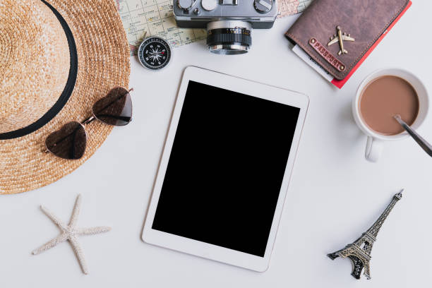 istock Empty screen smart device with travel accessories and items on white background with copy space, Travel concept 1190109119