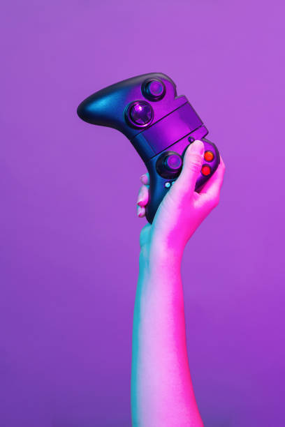 istock Hand with black gamepad on violet background. 1190109403