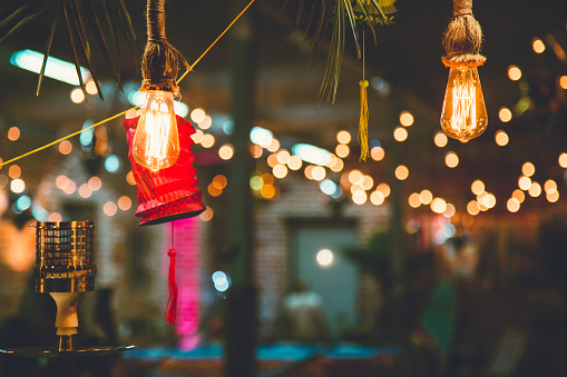 Colorful paper lanterns and bulbs hanging as a party decor. Night party.