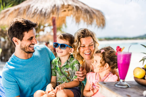 istock Happy parents having fun with their small kids in a beach bar. 1190110367