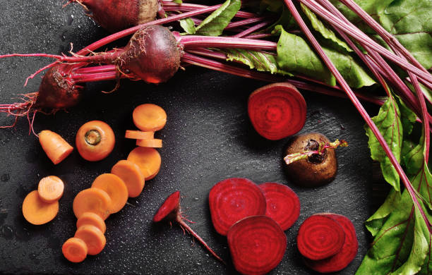 istock Top view at vegetable background of beets and carrots on kitchen table close up view 1190110424