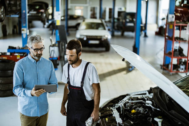 istock Mid adult inspector and auto repairman using touchpad in a workshop. 1190119017