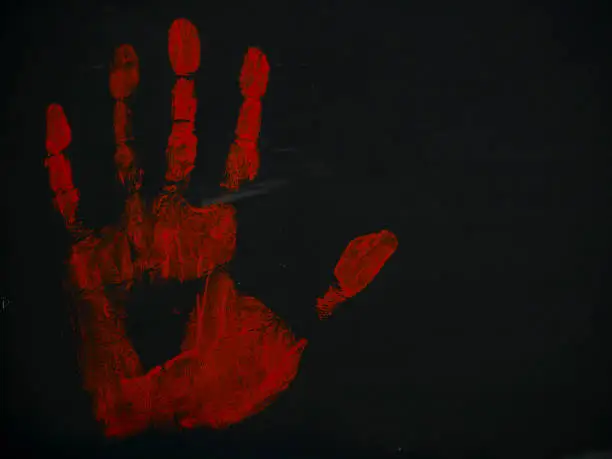 Photo of drawing bloody handprint on a black background
