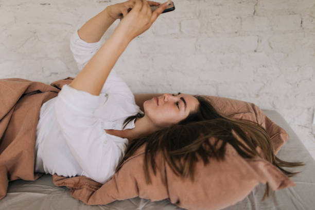 istock Young woman using smart phone in her bedroom 1190120367
