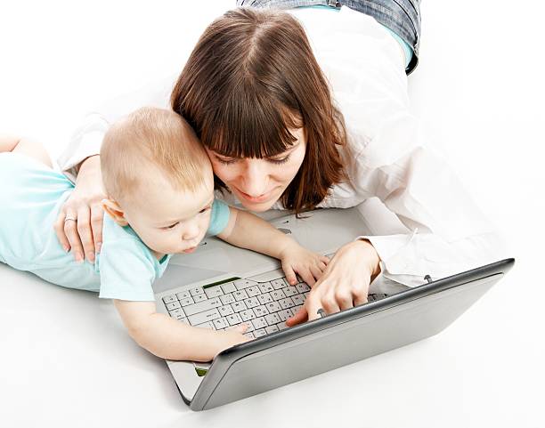 mother and baby with laptop stock photo