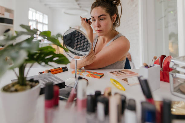 istock Young woman applying make-up 1190121900