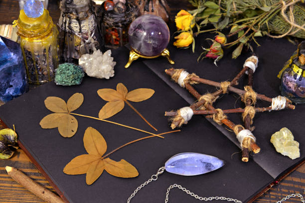 istock Pentagram, open diary, four-leaf clover and gemstone with herbs on witch table. 1190121992