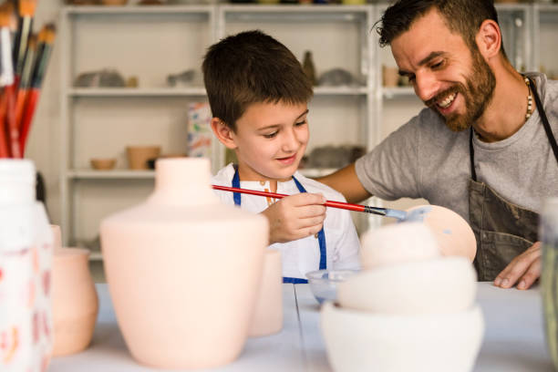 istock Son an father painting pottery 1190123874