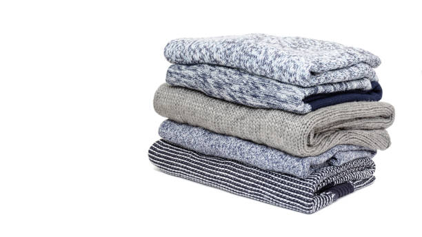istock Stack of folded woolen knitwear on white background: sweaters, jumpers in grey and blue tone. Winter wardrobe concept 1190124539