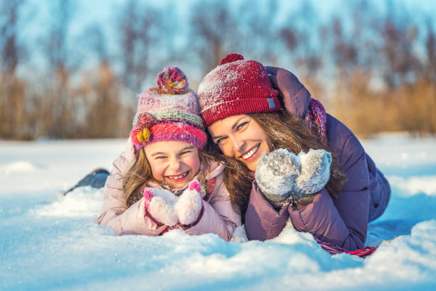 istock Active mother and daughter playing in winter park 1190126123